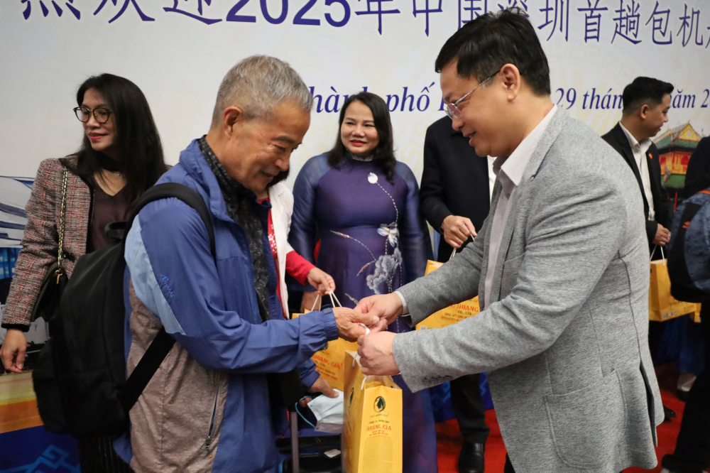 A city official gives a gift to a passenger of Donghai Airlines flight DZ6355 upon arrival at Phu Bai International Airport. (Photo: VNA) 