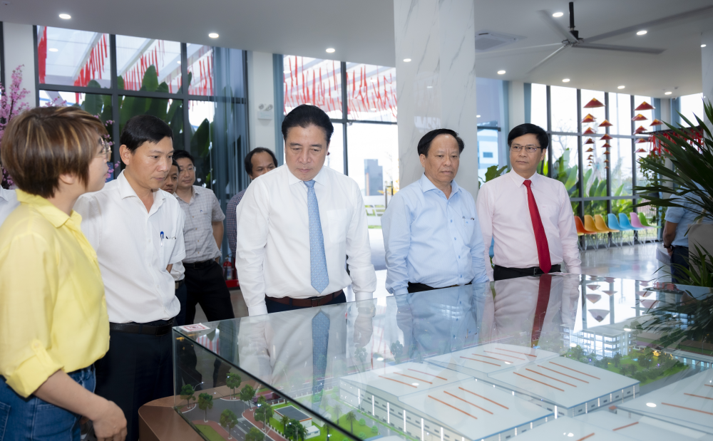 Chủ tịch UBND thành phố Nguyễn Khắc Toàn (ở giữa) tham quan mô hình sản xuất Công ty TNHH EON Industry Việt Nam