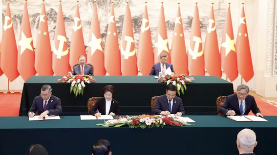 Minister of Industry and Trade Le Manh Hung and Minister of Commerce of China Wang Wentao jointly signs the “Memorandum of Understanding on the establishment of a working group to negotiate and promote the building of a Vietnam - China cross-border economic cooperation zone” and the “Memorandum of Understanding on the establishment of a working group on Vietnam - China production and supply chain cooperation.” Photo: Nhan Dan Newspaper