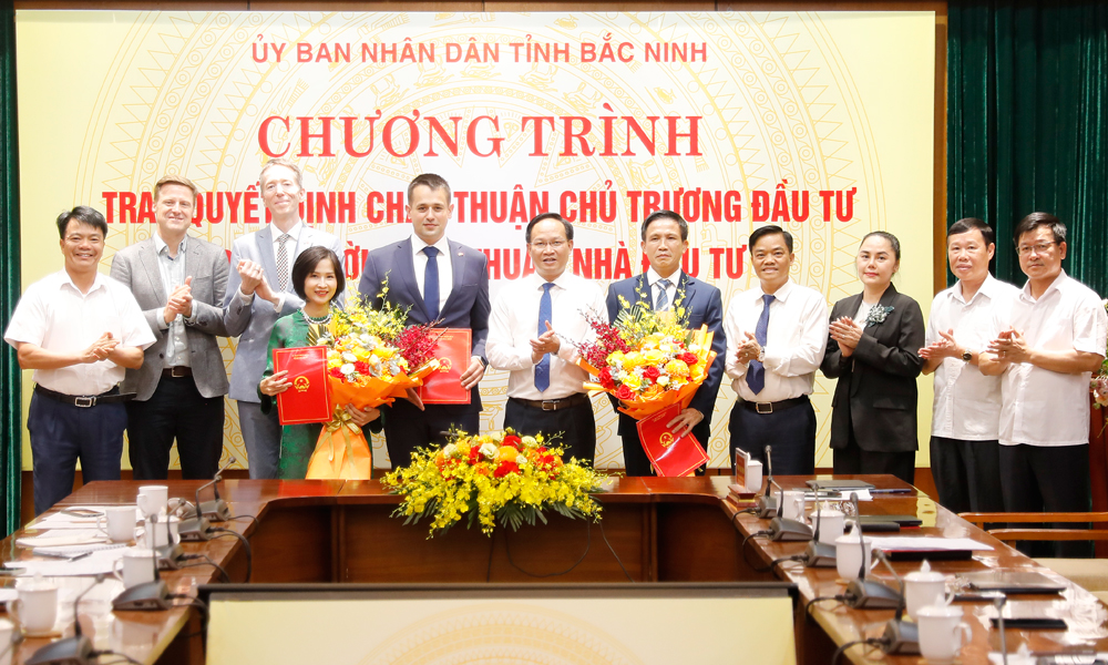 Đồng chí Phạm Văn Thịnh trao các quyết định chấp thuận đầu tư và tặng hoa chúc mừng các nhà đầu tư.